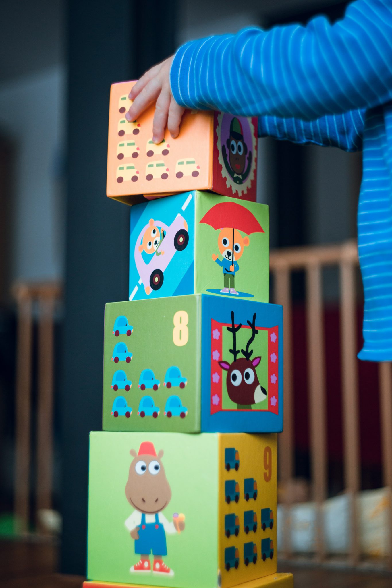 A toddler from ABA Therapy placing the final block on a stack of blocks.